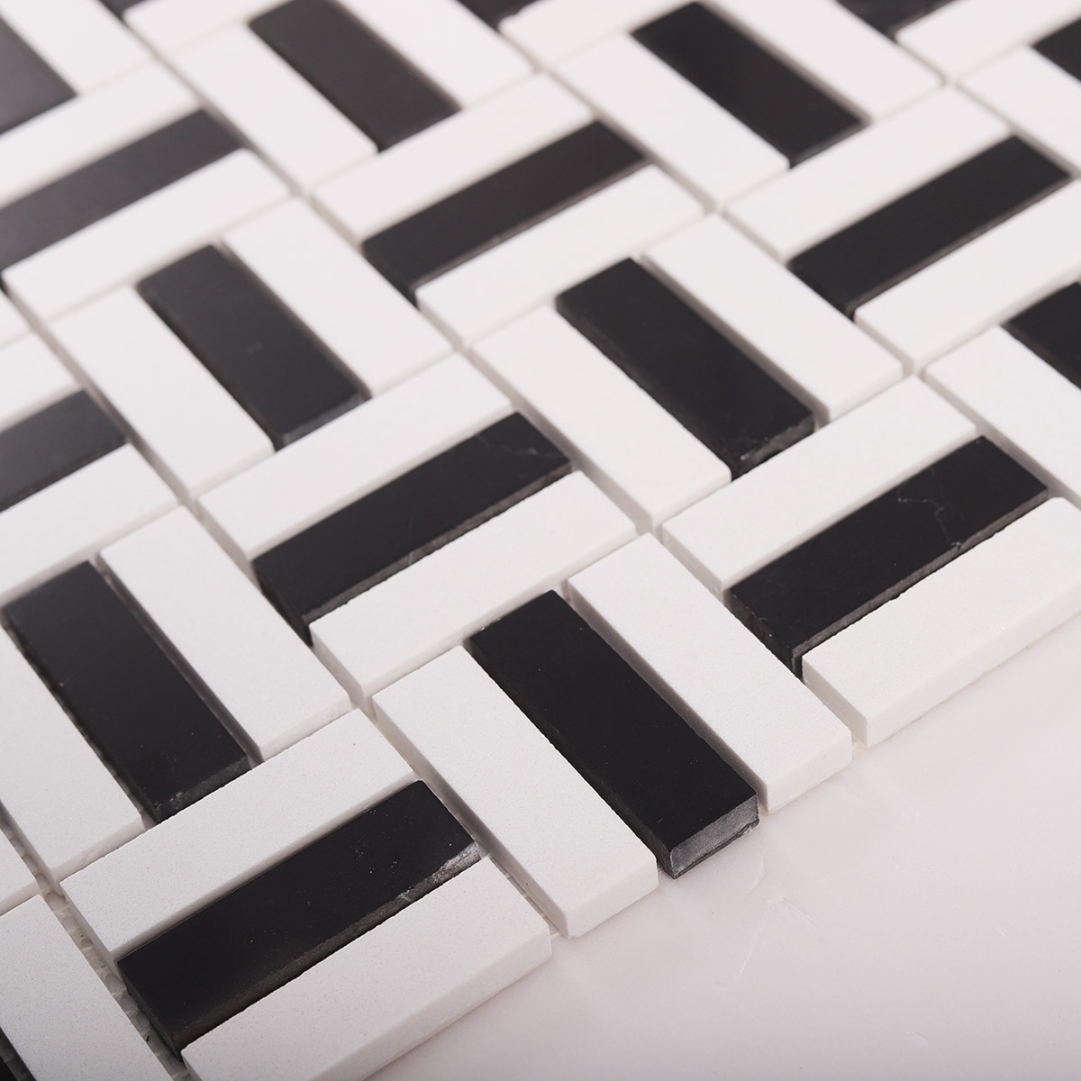 Side close-up view of black and white faux marble mosaic tiles, showing texture and thickness.