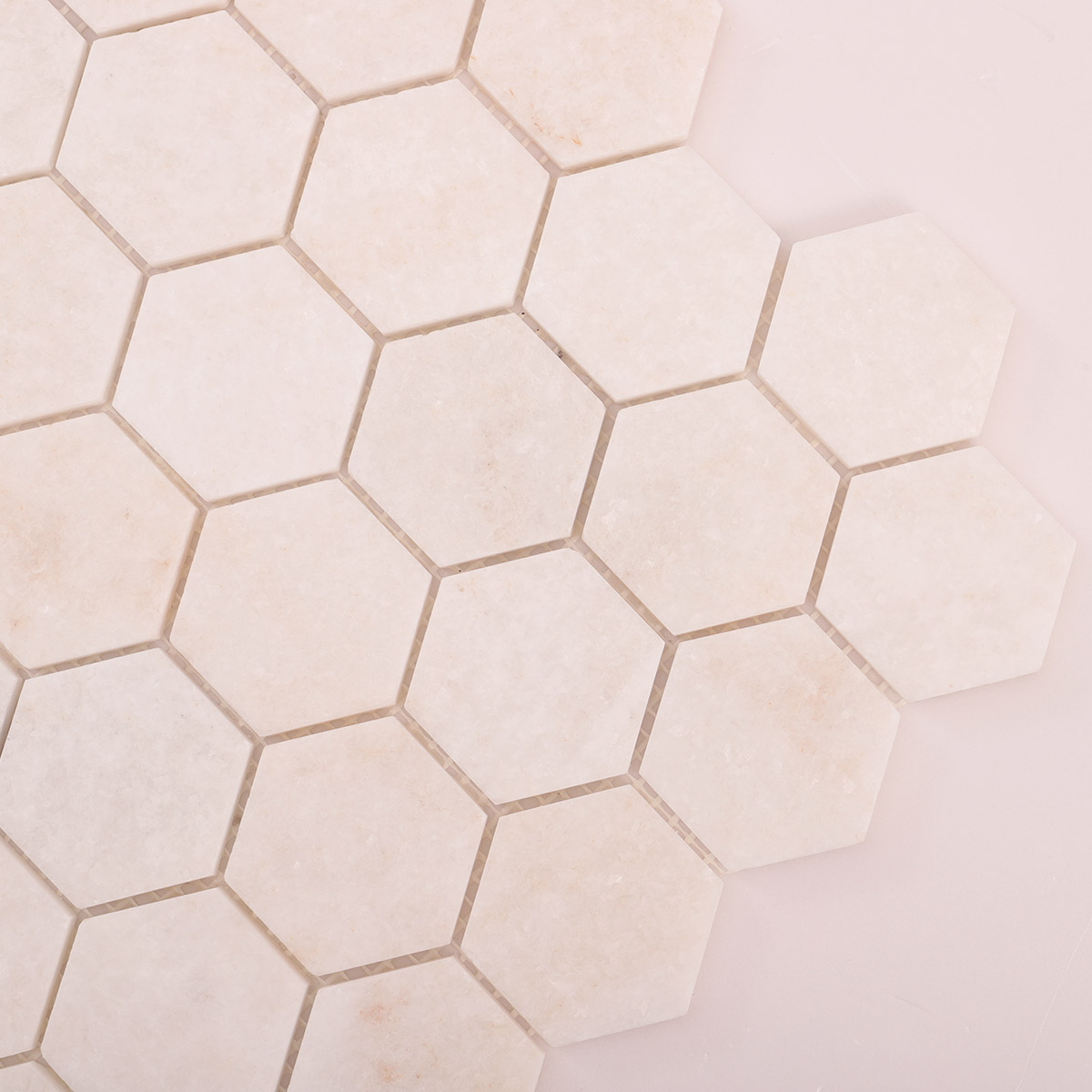 Detailed close-up of crystal white hexagon marble mosaic tiles.