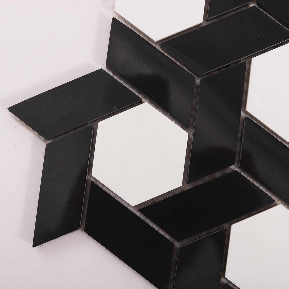 Close-up view of white and black lattice pattern natural stone mosaic tiles.