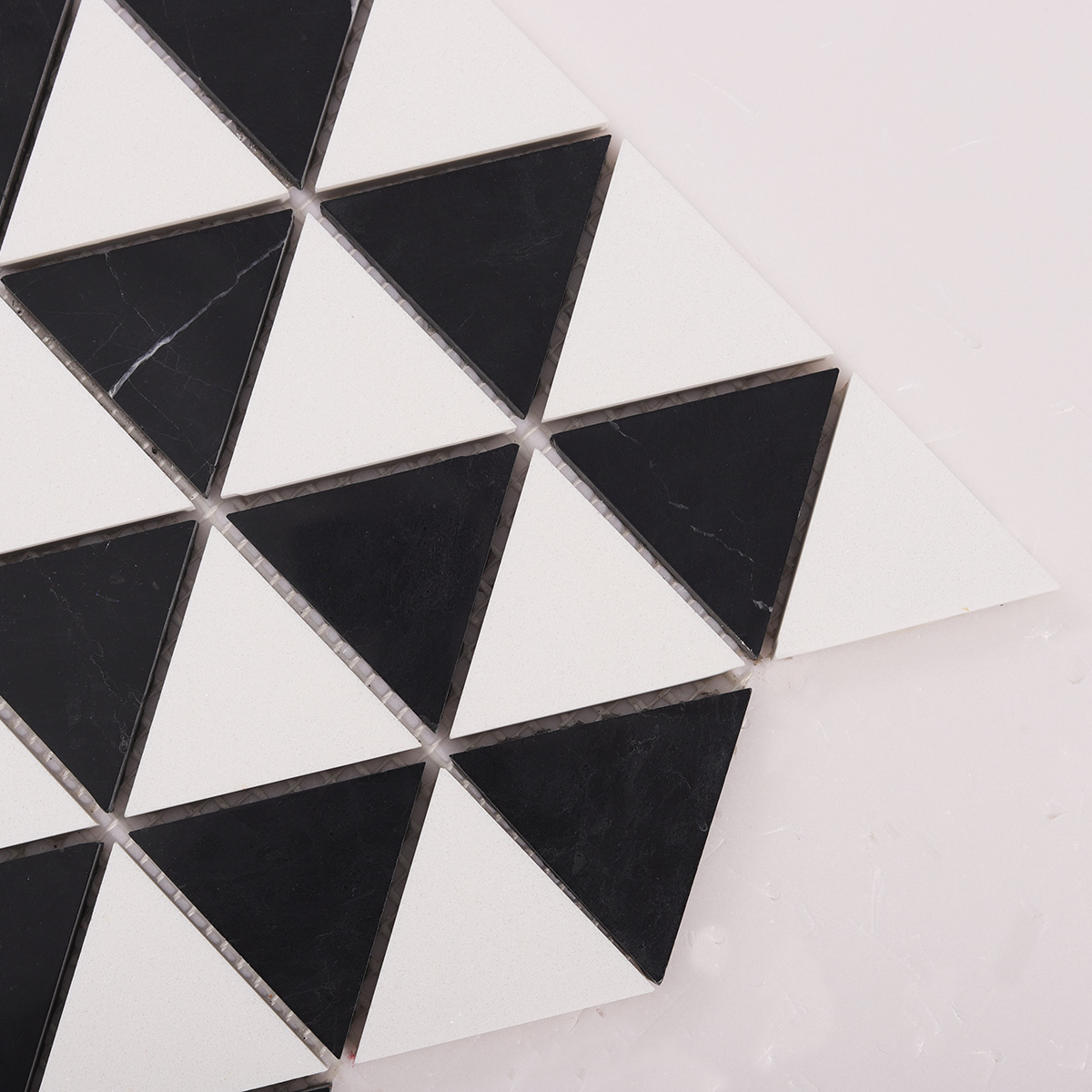 Detailed close-up of White and Black Triangle Honed Stone Mosaic Tiles