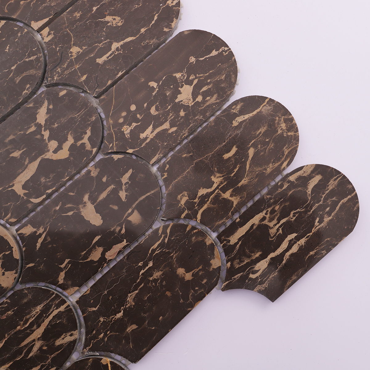 Close-up of dark marble mosaic tile showing gold veins and glossy finish