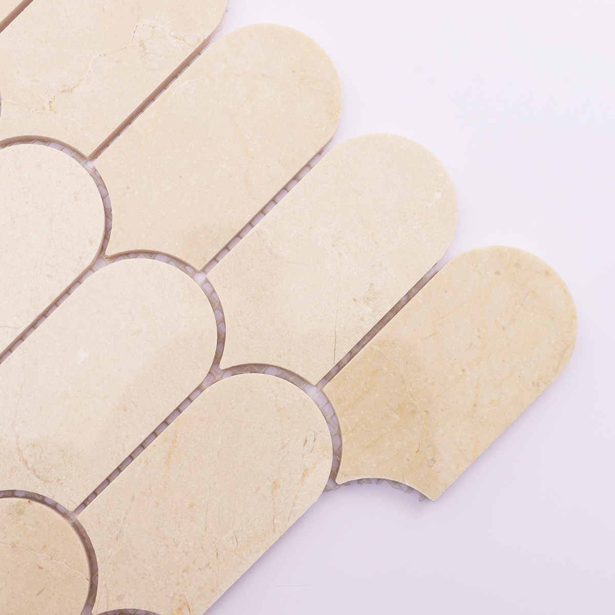 Detailed view of beige marble mosaic tile, showcasing gentle veins and polished texture.