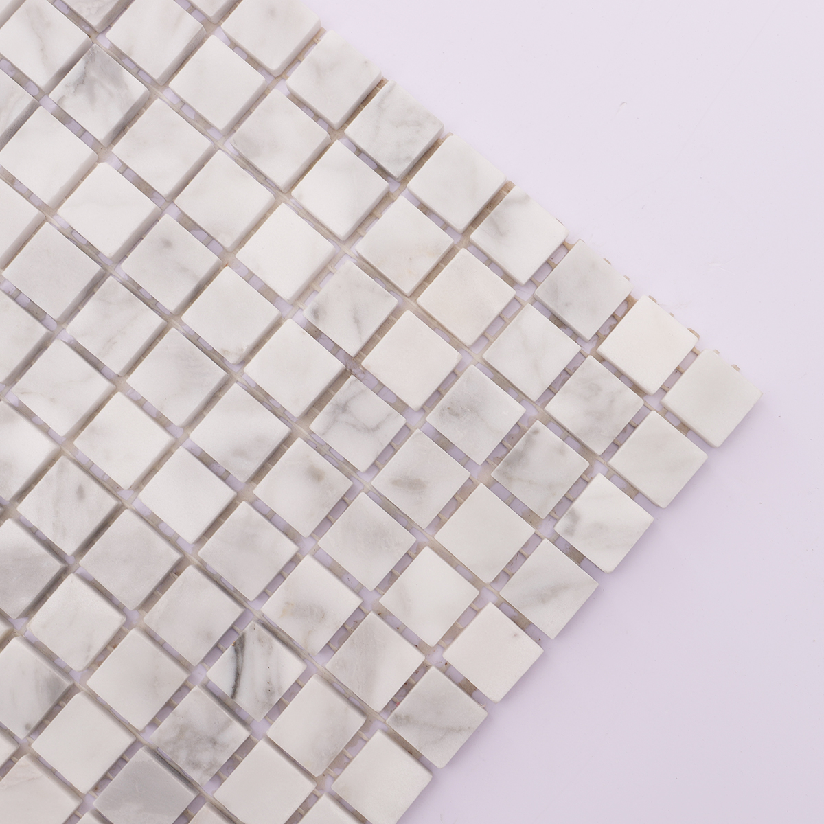 Zoomed-in view highlighting the texture and finish of Carrara white honed marble tiles.