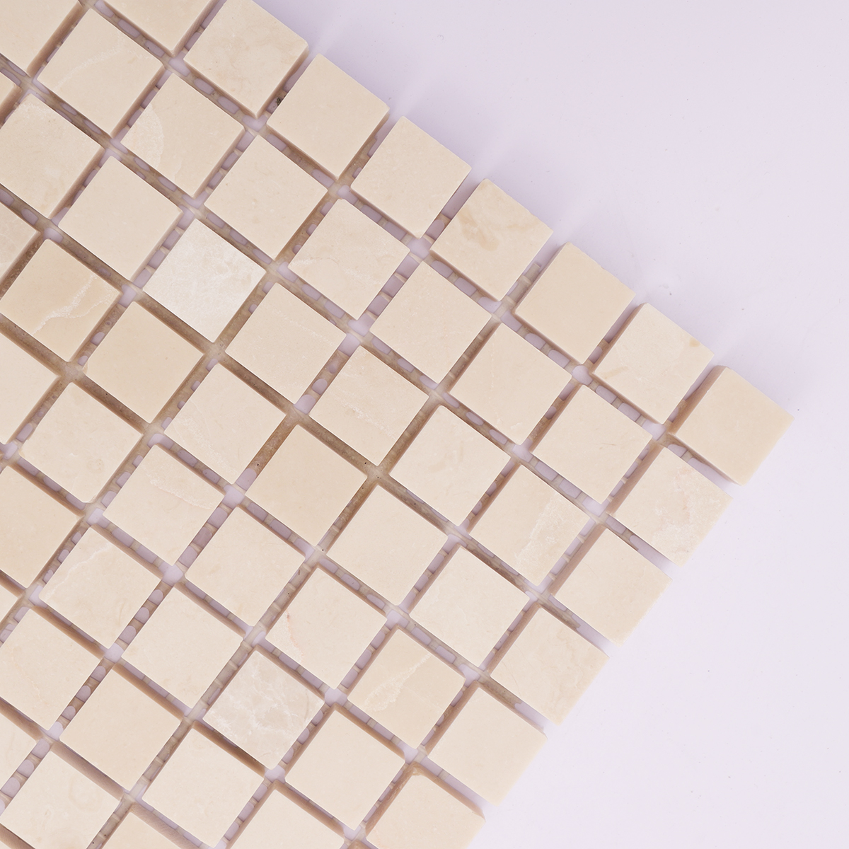 Close-up of the smooth polished surface of beige marble backsplash tiles.