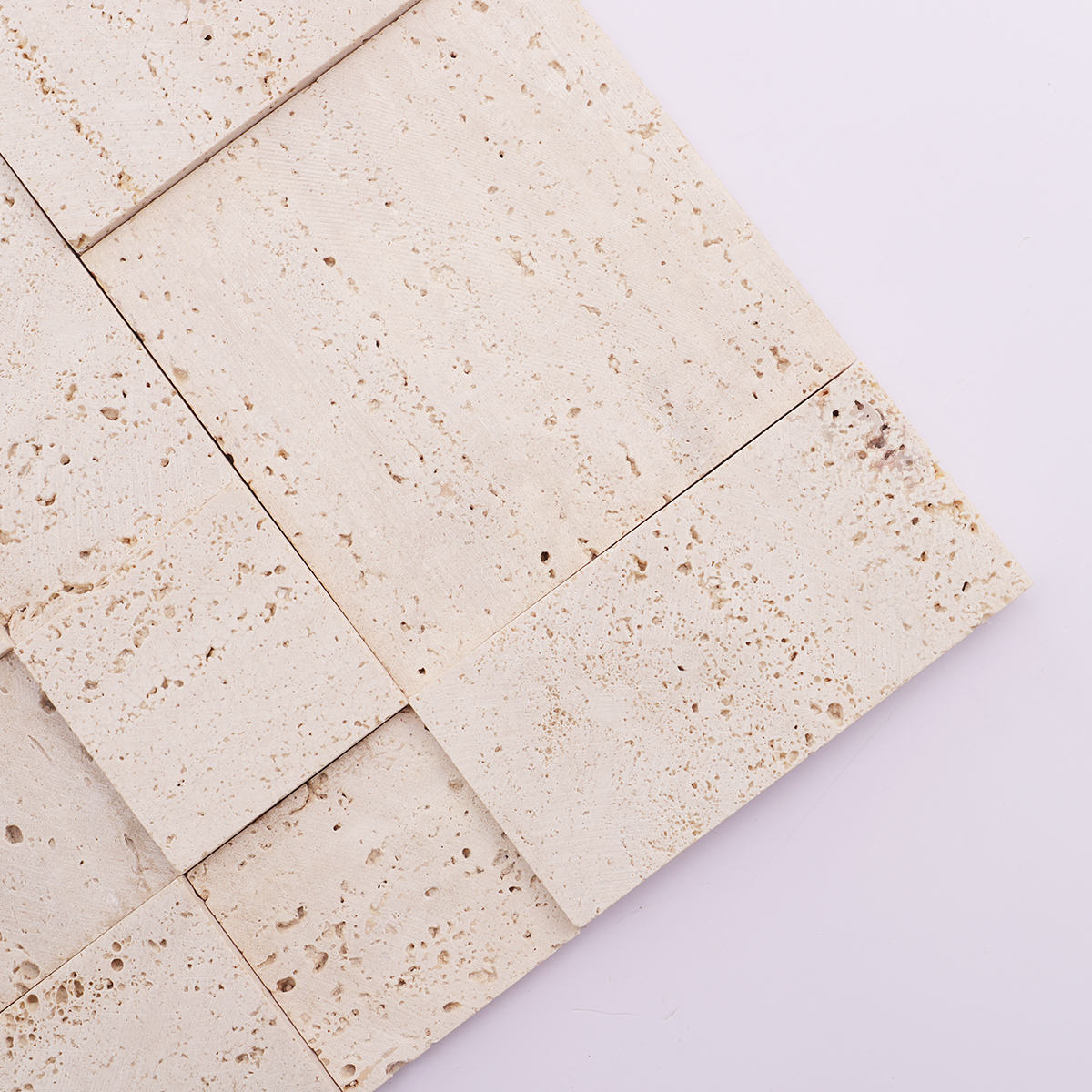 Close-up of the 3D texture and design of beige travertine mosaic wall tiles