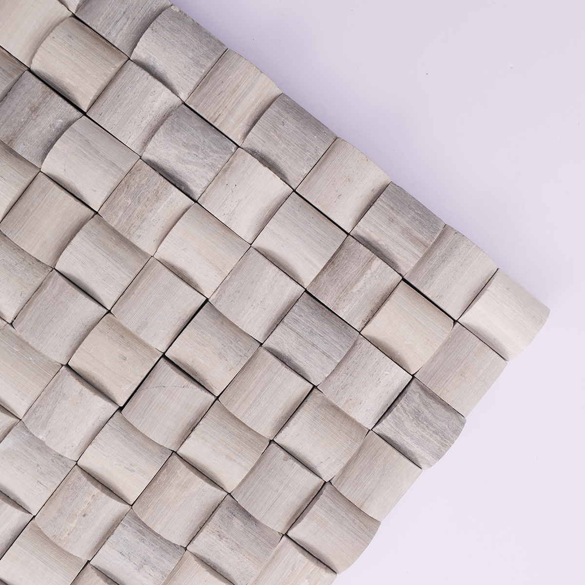 Close-up showing the 3D curved design of gray marble mosaic tiles.