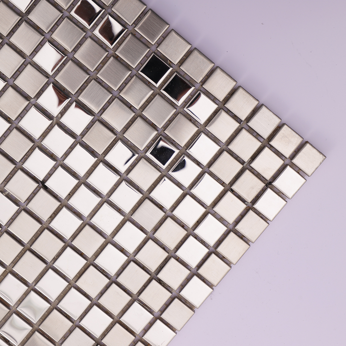 Close-up highlighting the brushed and reflective finish of the silver metal tiles.