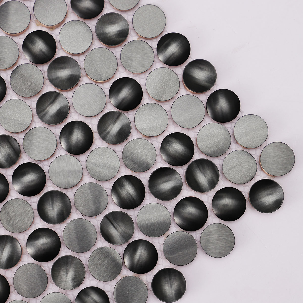 Surface detail close-up of 3D black penny round metal mosaic tiles.