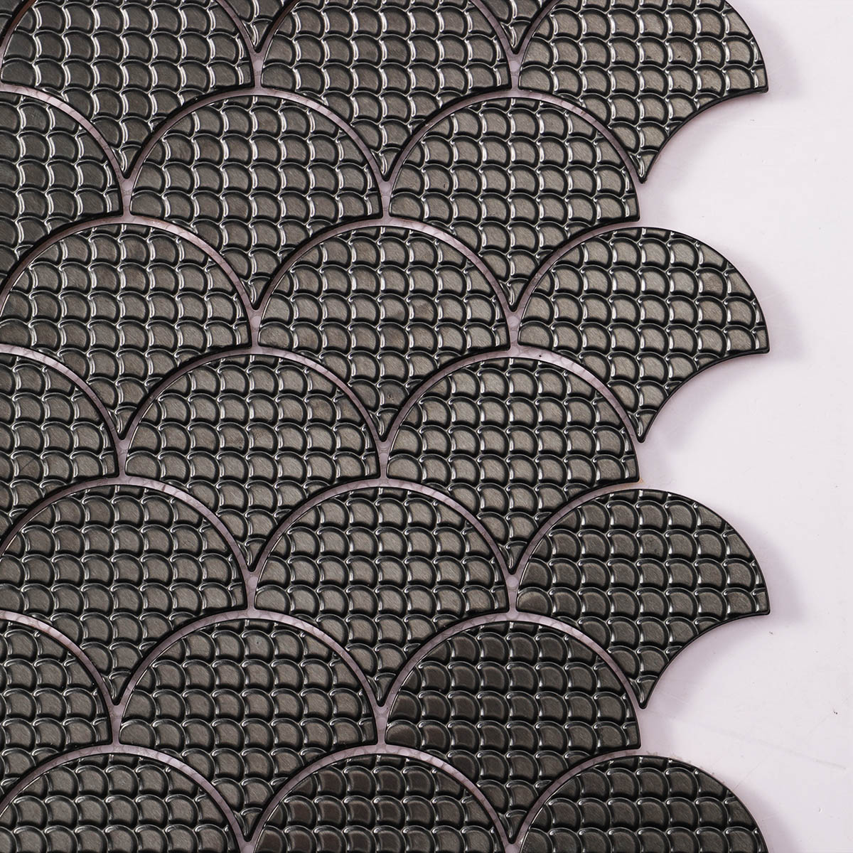 Pattern detail close-up of black metal fish scale pattern mosaic tiles.