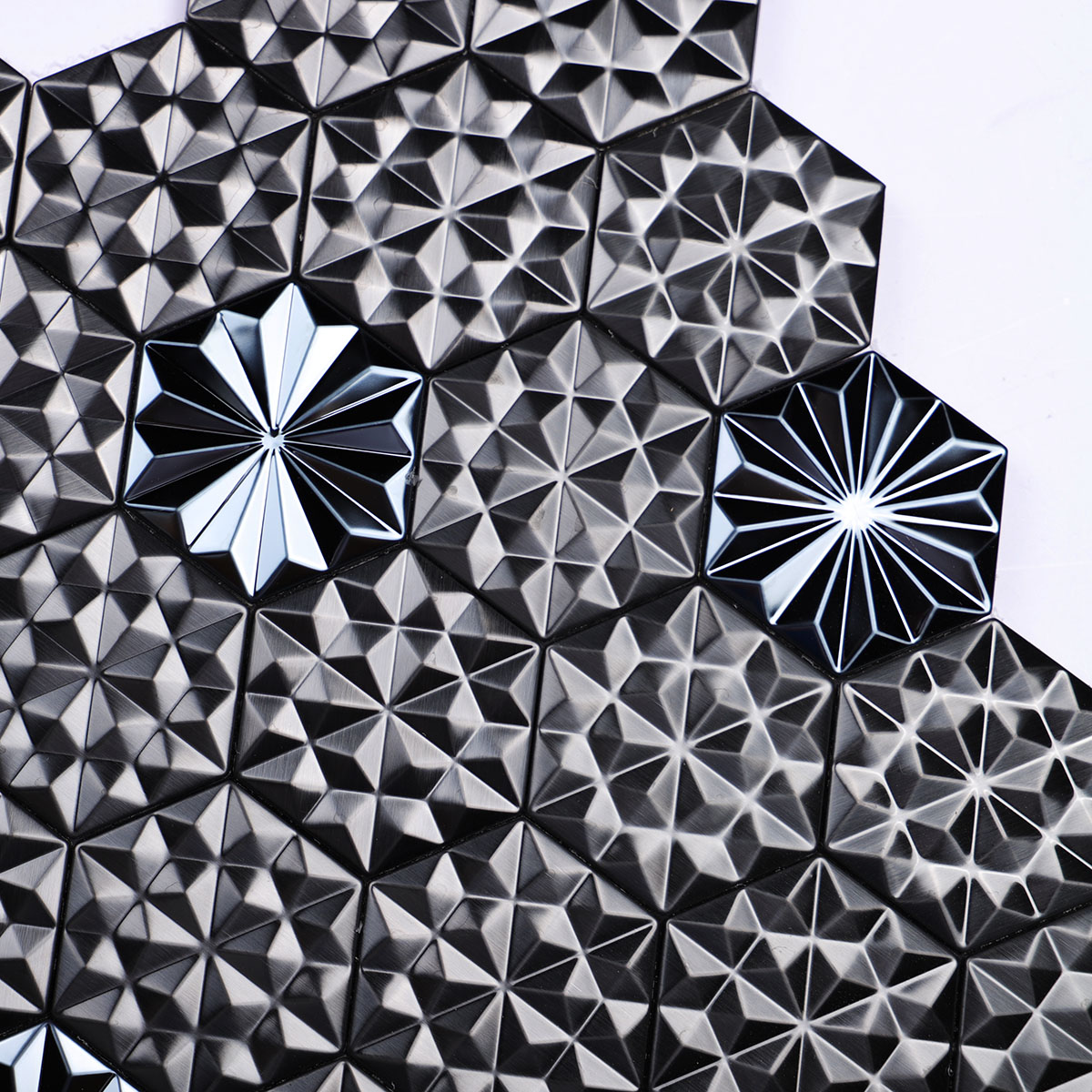 Close-up view of black metal 3D groutless hexagon mosaic tile in stainless steel.