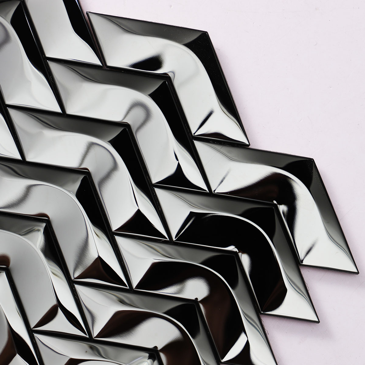 Close-up of black stainless steel chevron 3D mirror mosaic tiles. 