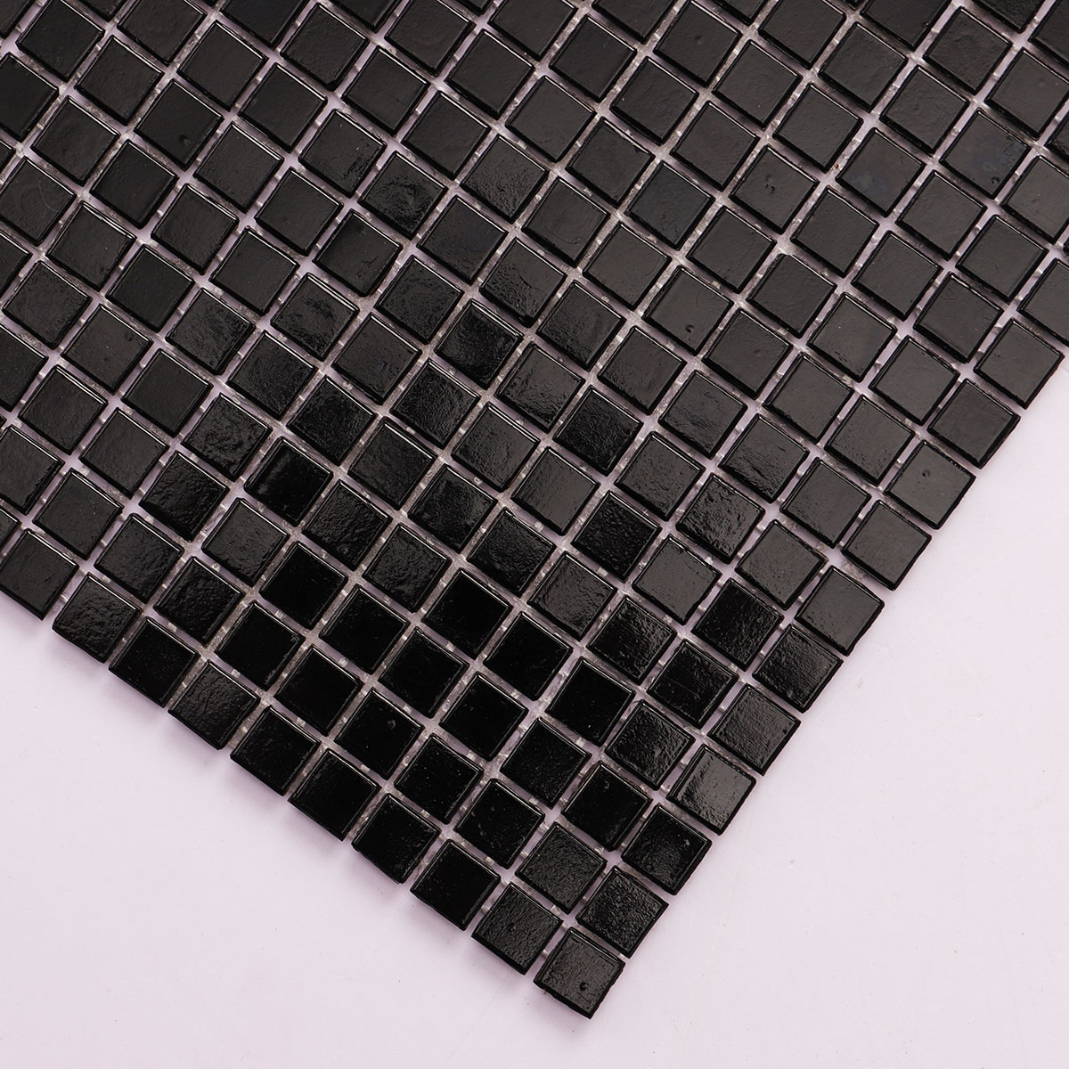 Detailed close-up of black square glass tiny mosaic tiles 10mm x 10mm.