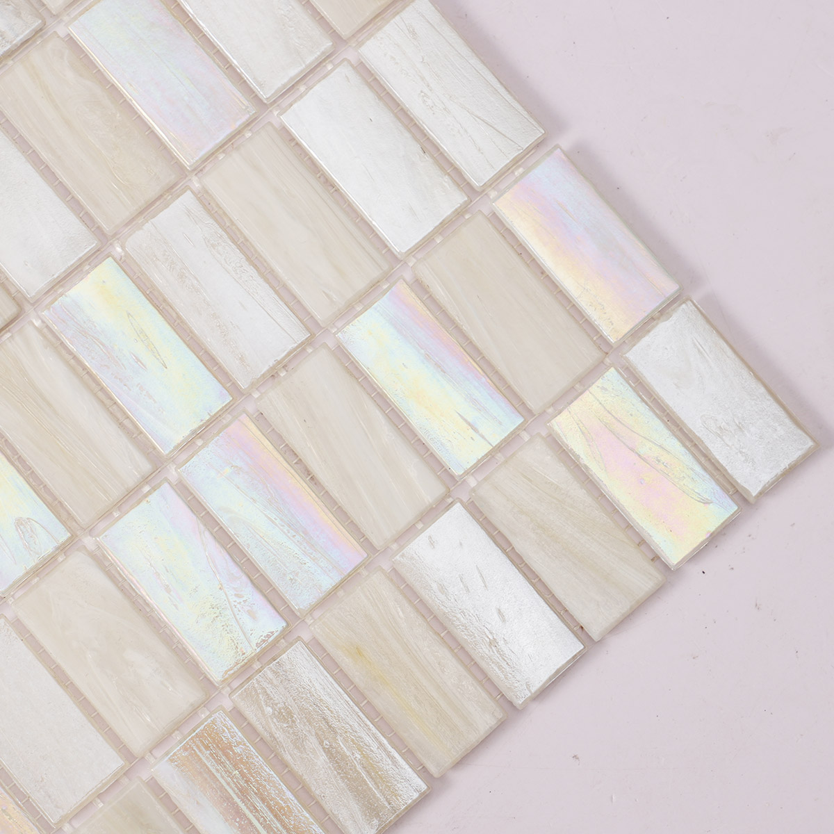 Detailed close-up of rectangle beige multicolor iridescent glass mosaic tiles.