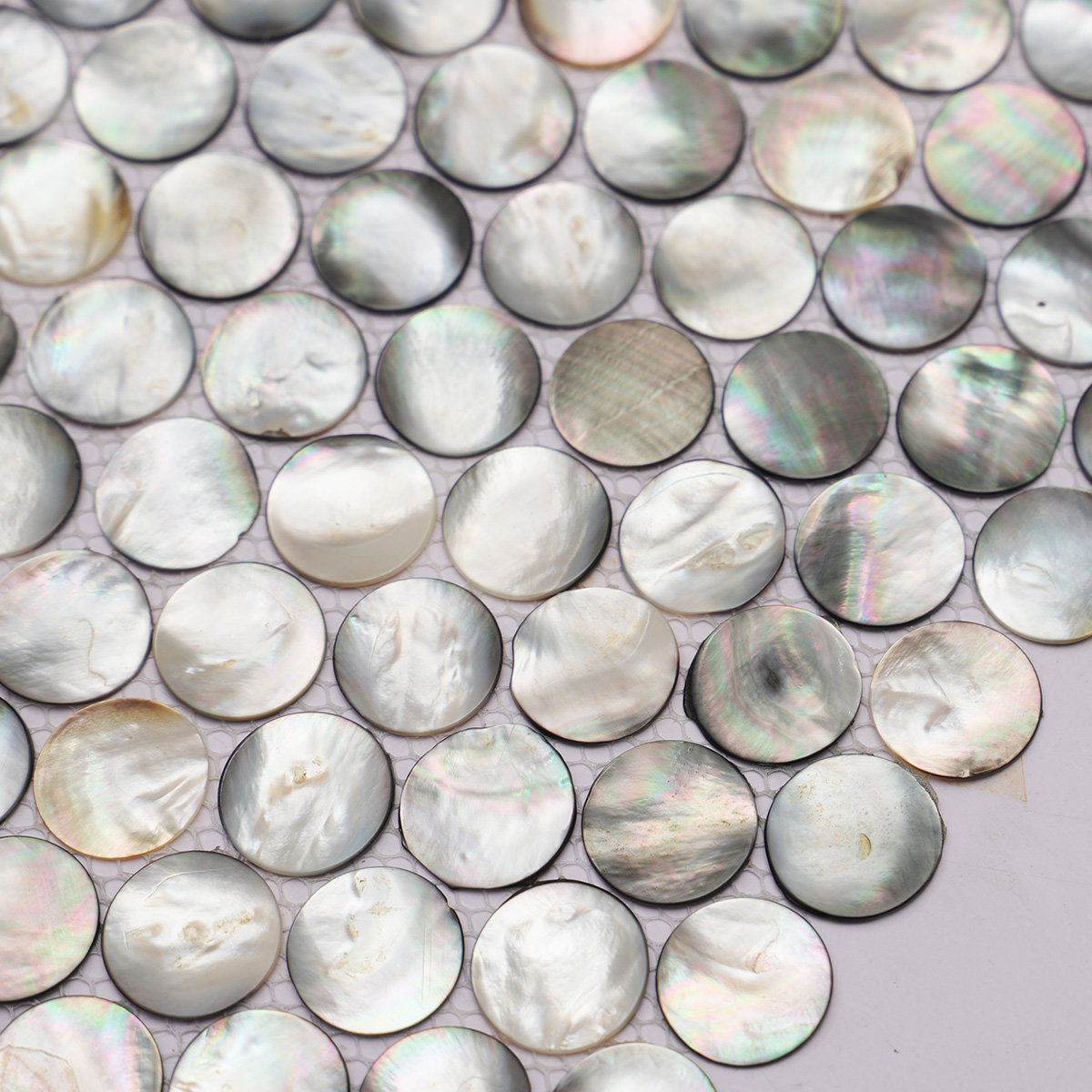 Close-up view of black mother of pearl penny round tiles, second shot.