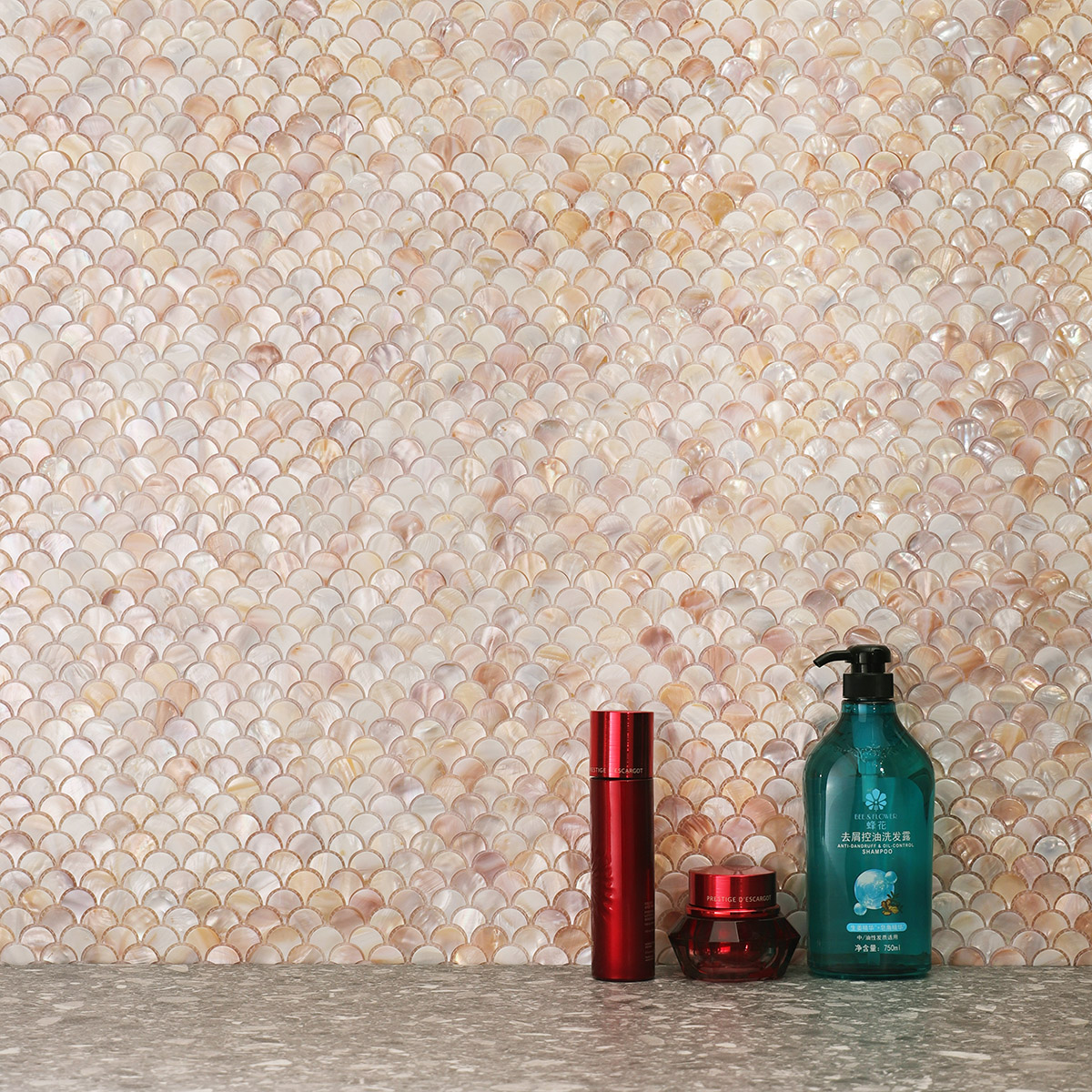 Bathroom with mother of pearl fish scale tiles, gray floor, and skin care products