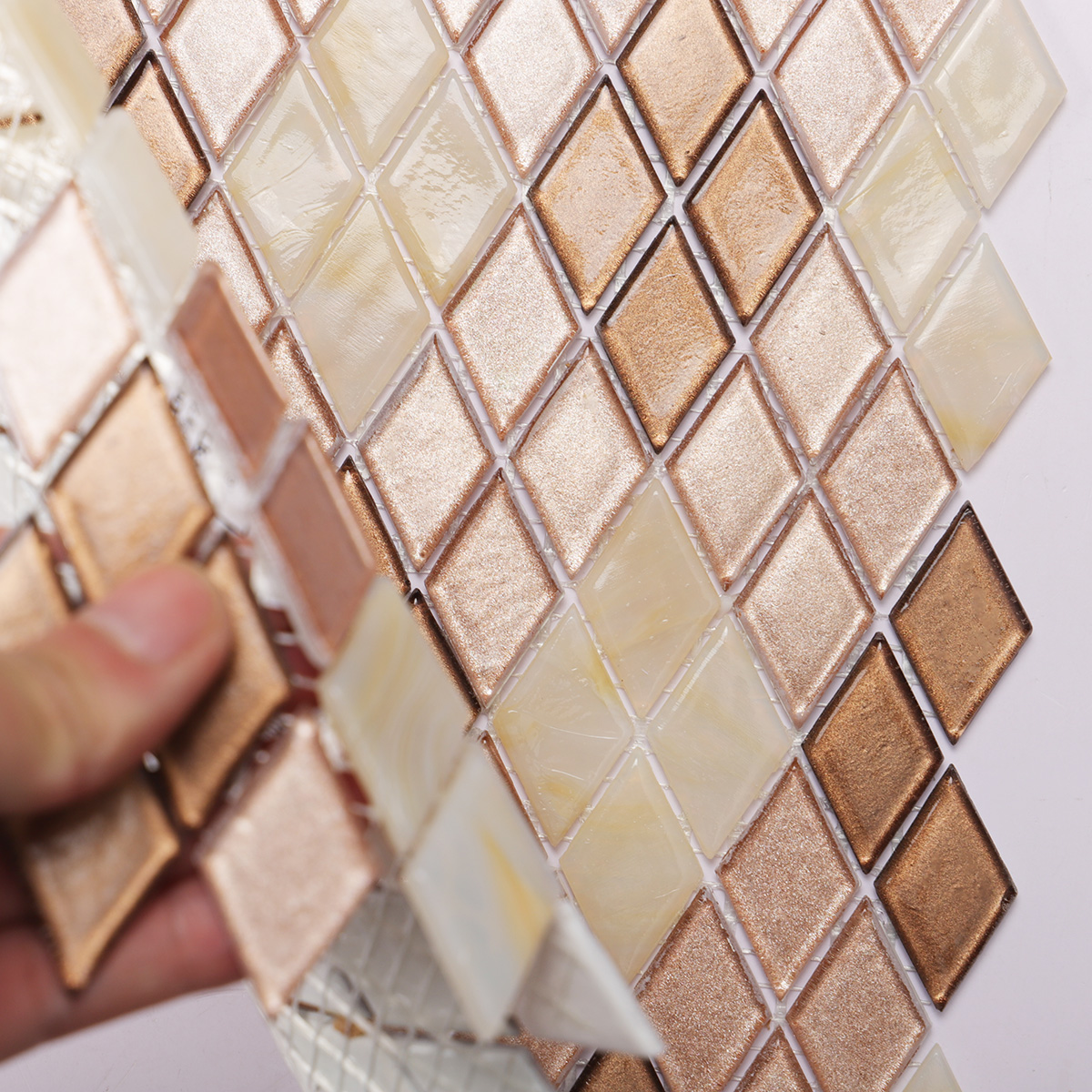 Close-up of beige diamond-patterned glass mosaic tiles