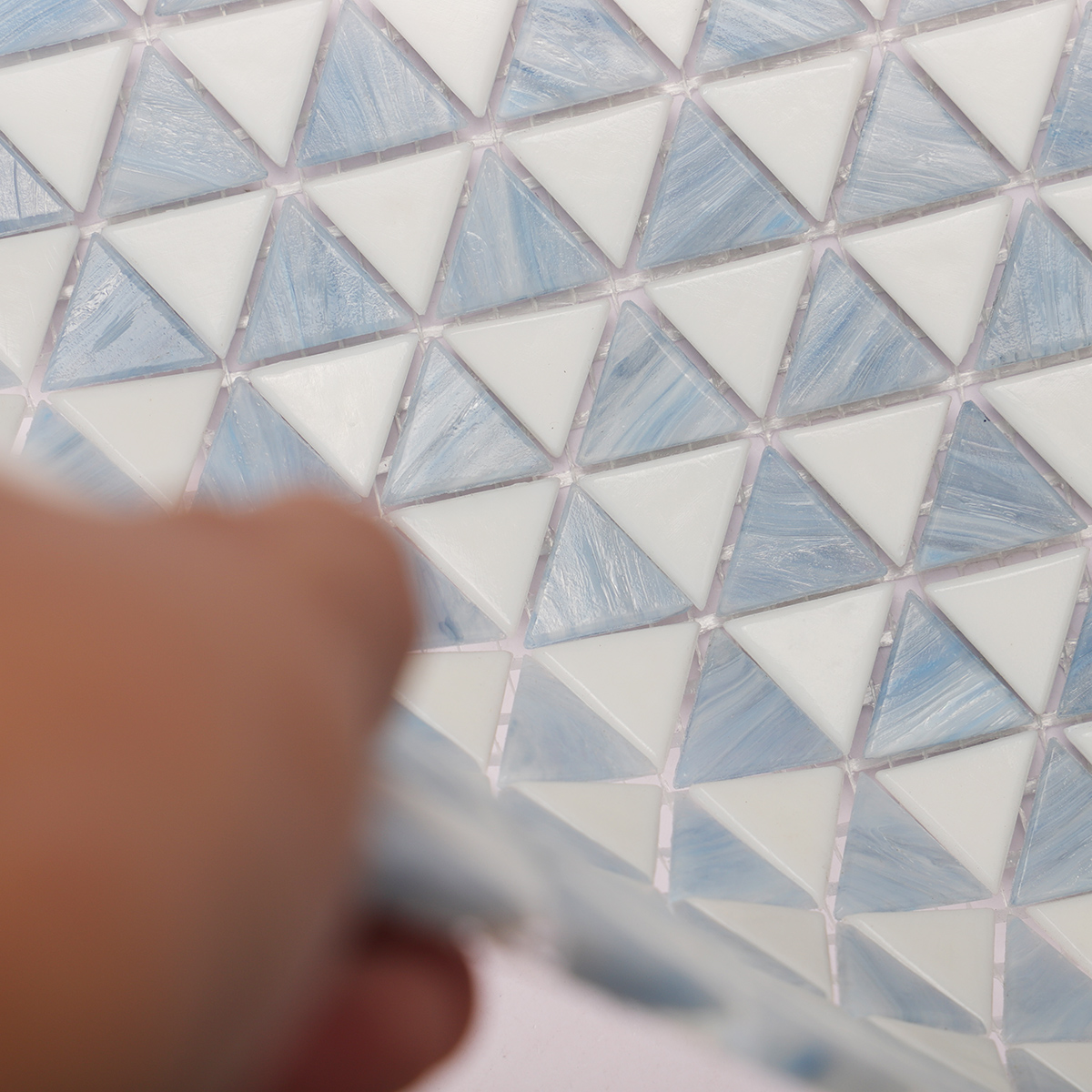Third close-up of blue and white checkerboard triangle glass mosaic tiles.