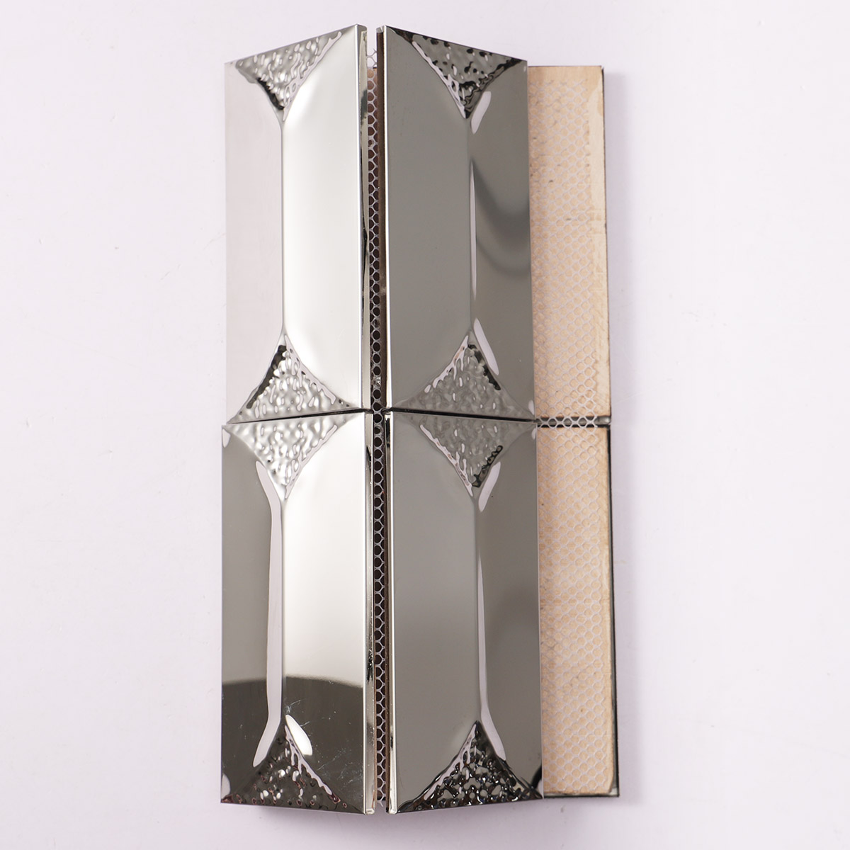 Back side of 3D glossy silver rectangle metal mosaic tiles, showing fold