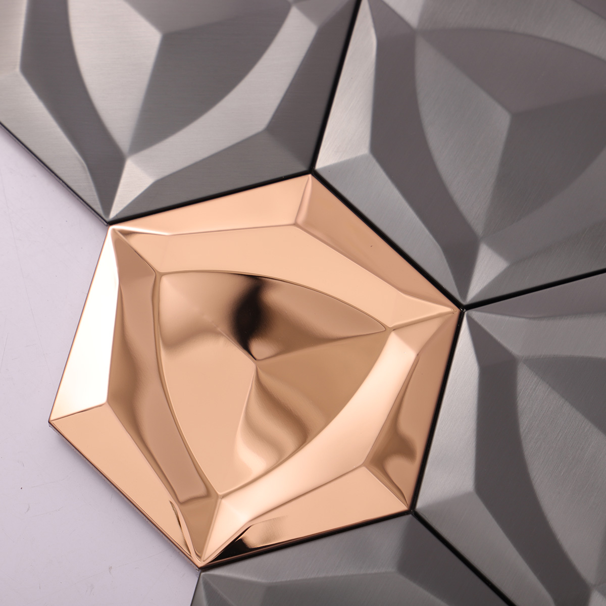 Close-up of 3D black and gold hexagon metal mosaic tiles.