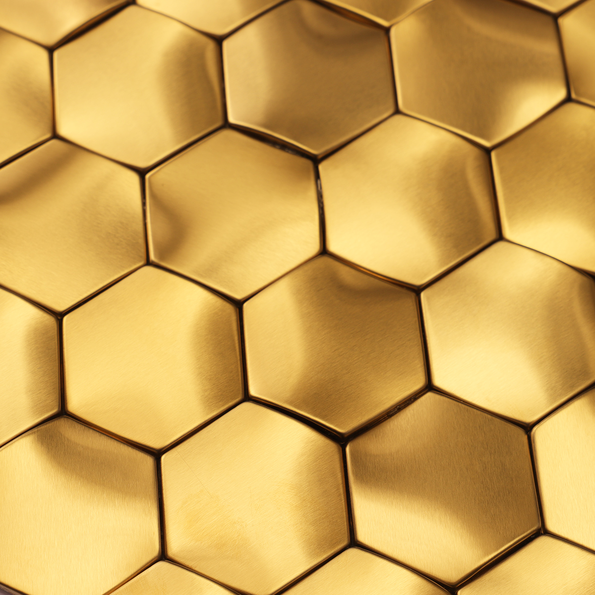 Detailed close-up of 3D gold stainless steel hexagon mosaic tiles.