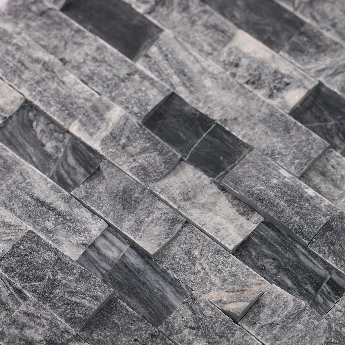 Detailed close-up of gray split face marble mosaic wall tiles.
