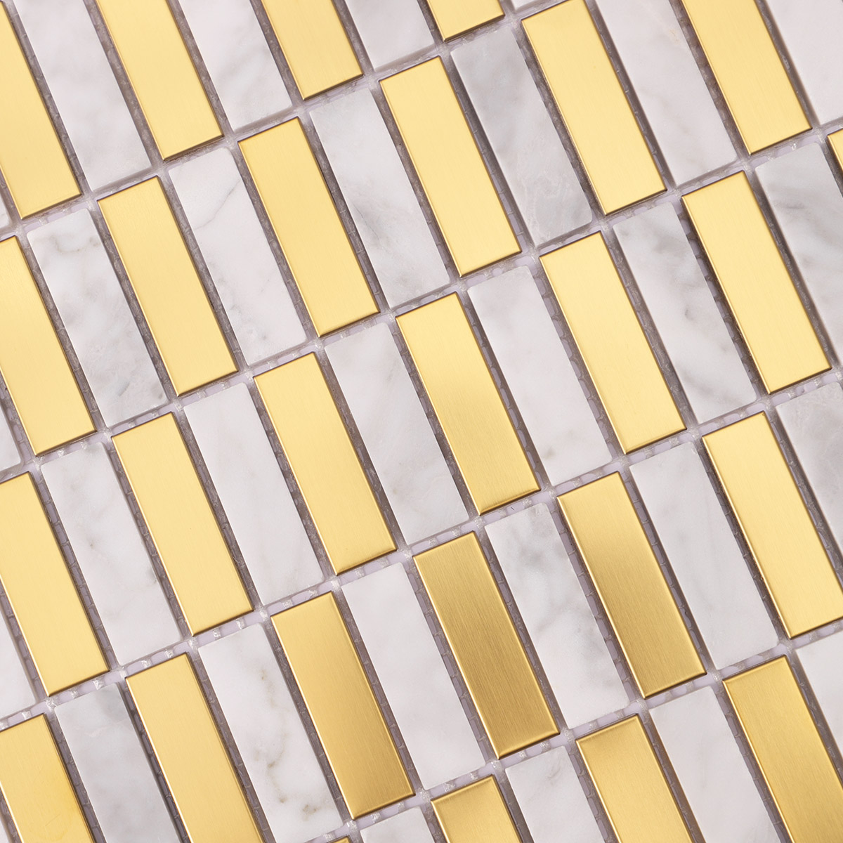 Close-up view of gold metal and Carrara white marble mosaic tiles.