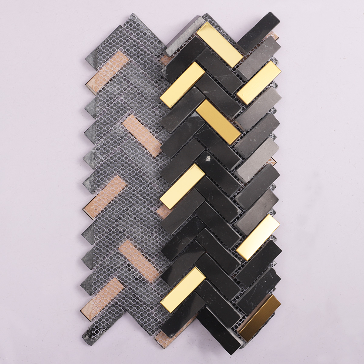 Folded back side of black marble and gold metal gradient mosaic tiles.