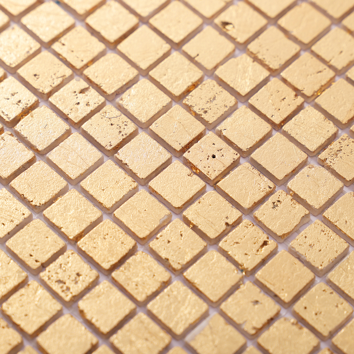 Detailed close-up of gold foil square travertine mosaic tiles.