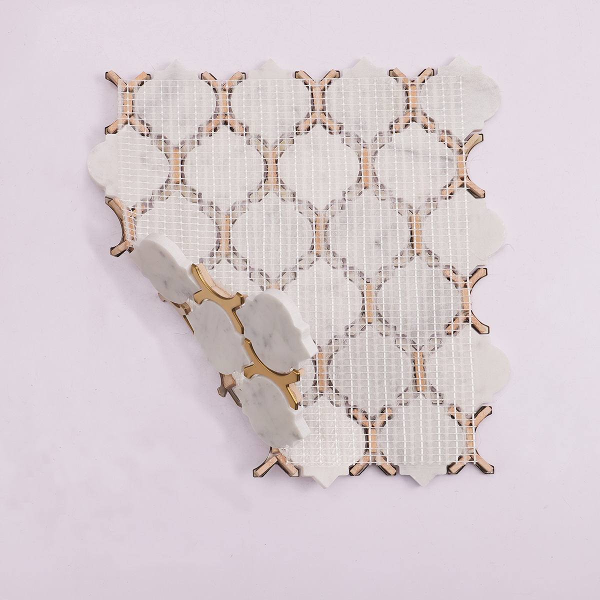 Folded back side of Carrara white marble and gold metal arabesque mosaic tiles.