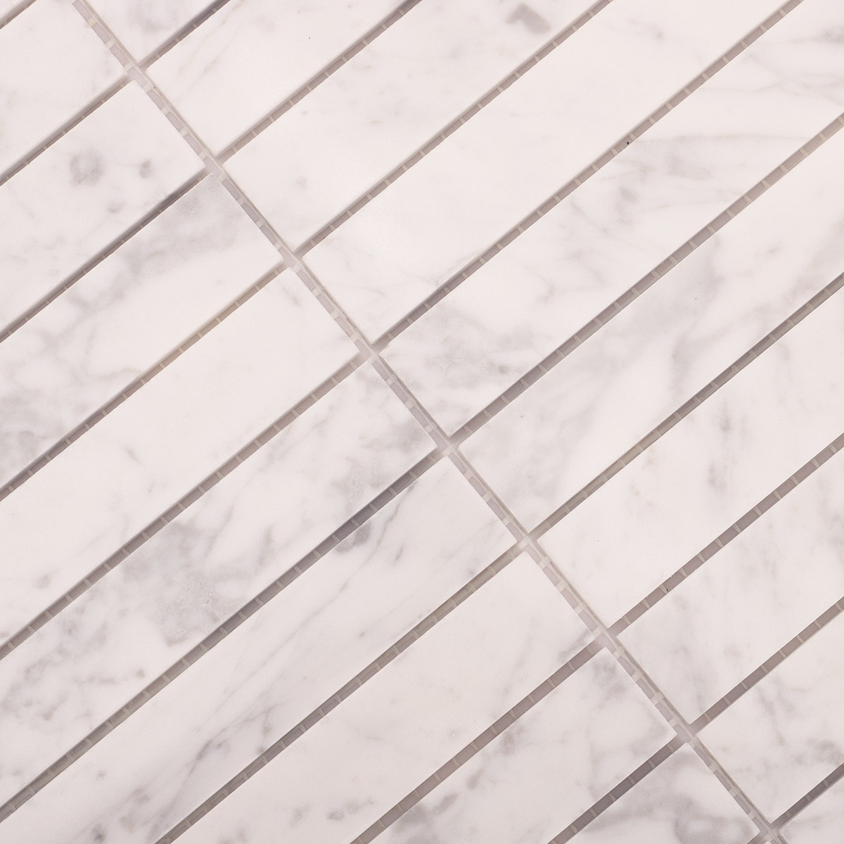 Detailed close-up of Carrara white marble stacked polished mosaic tiles.