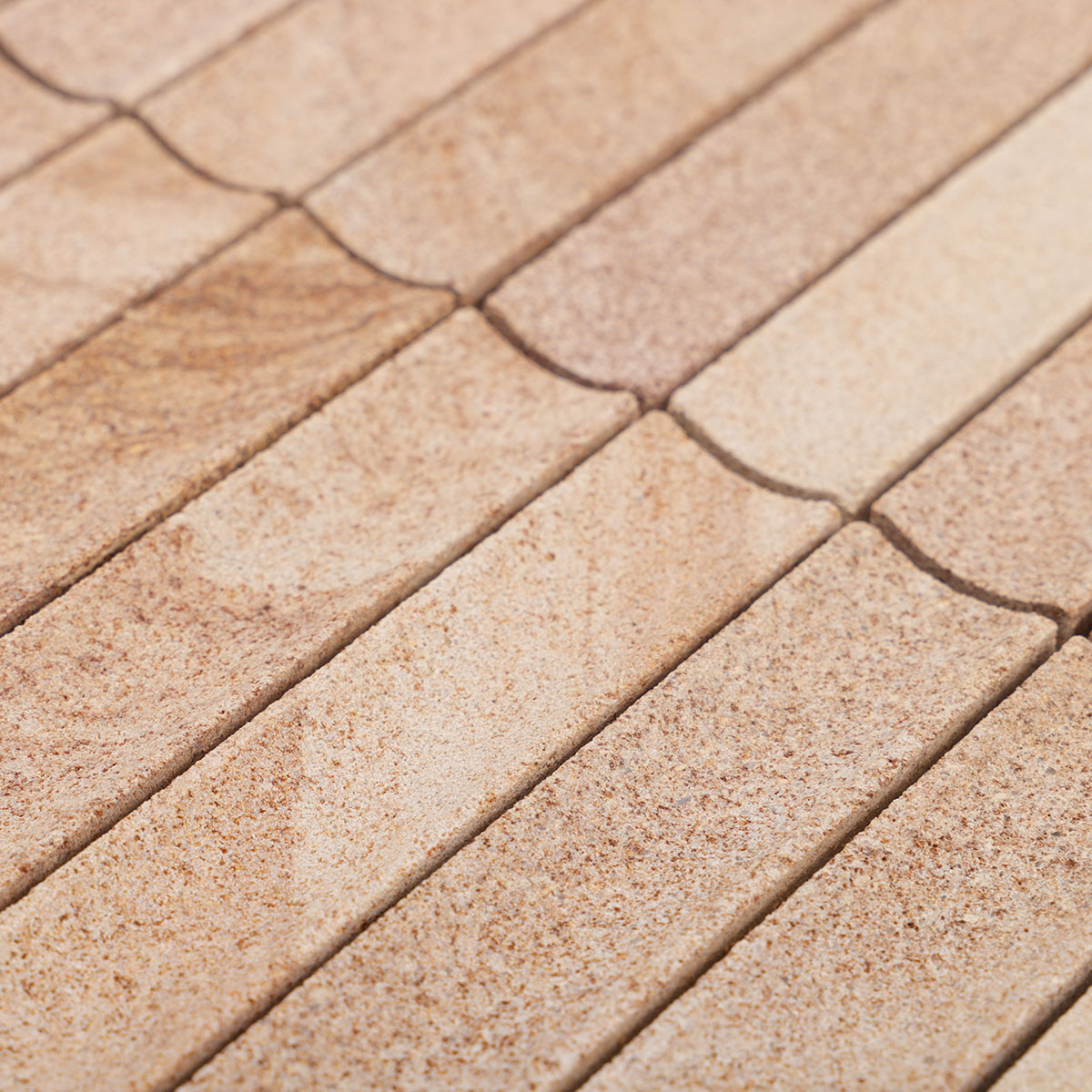 Detailed close-up of travertine concave honed fluted strip mosaic tiles.