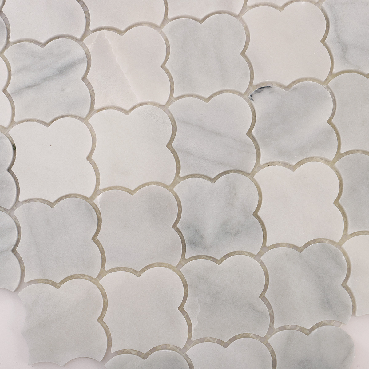 Detailed close-up of Carrara white cloud natural stone mosaic tiles.