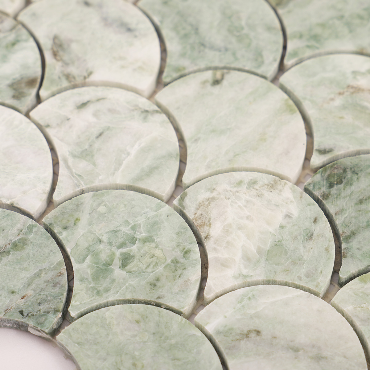 Close-up of emerald green marble fish scale mosaic tiles.