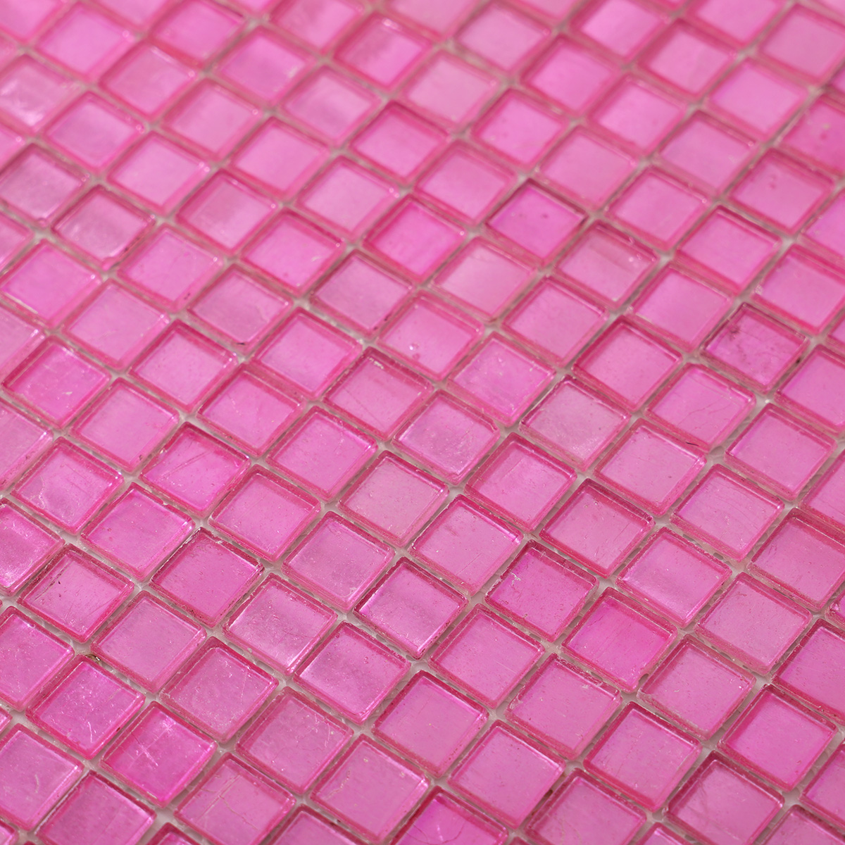 Close-up of glossy uniform square pink foil glass mosaic tiles