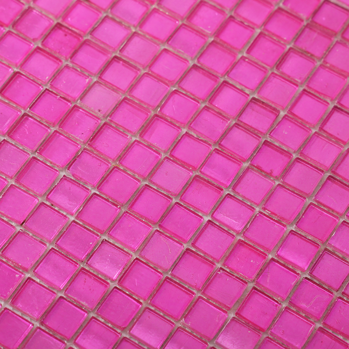 Close-up view of pink foil square glass mosaic tiles.