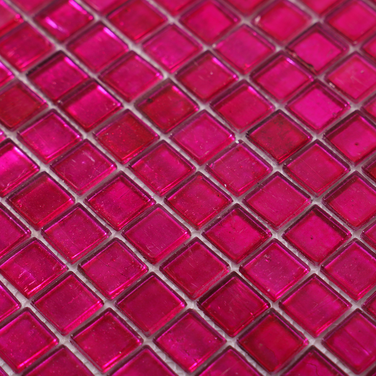 Close-up of dark pink foil glossy square glass mosaic tiles.