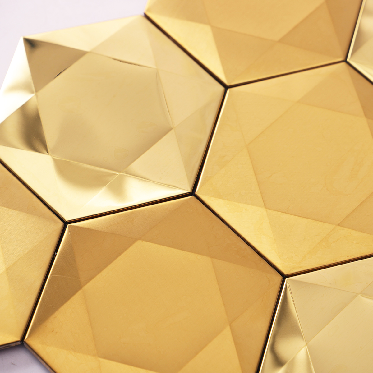 Detailed close-up of big hexagon 3D gold stainless steel metal mosaic tiles.