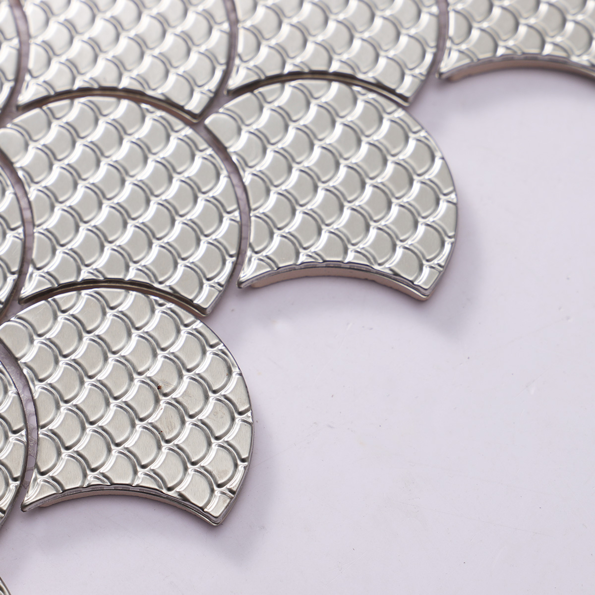 Close-up of silver fish scale stainless steel metal mosaic tiles.