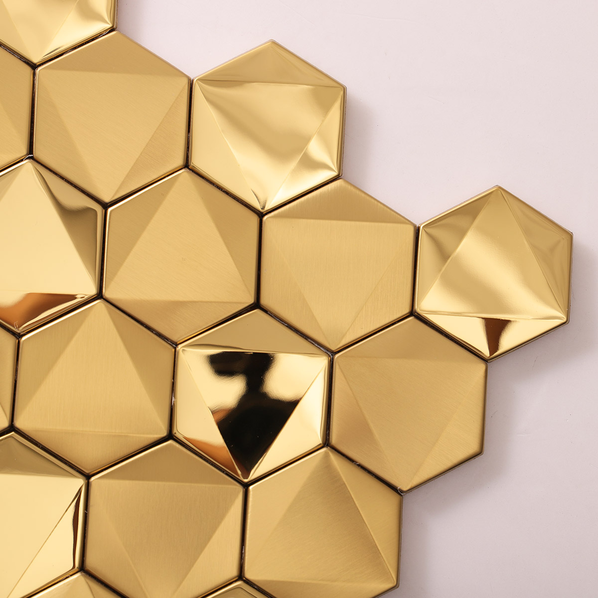 Detailed close-up of hexagon gold 3D stainless steel mosaic tiles.