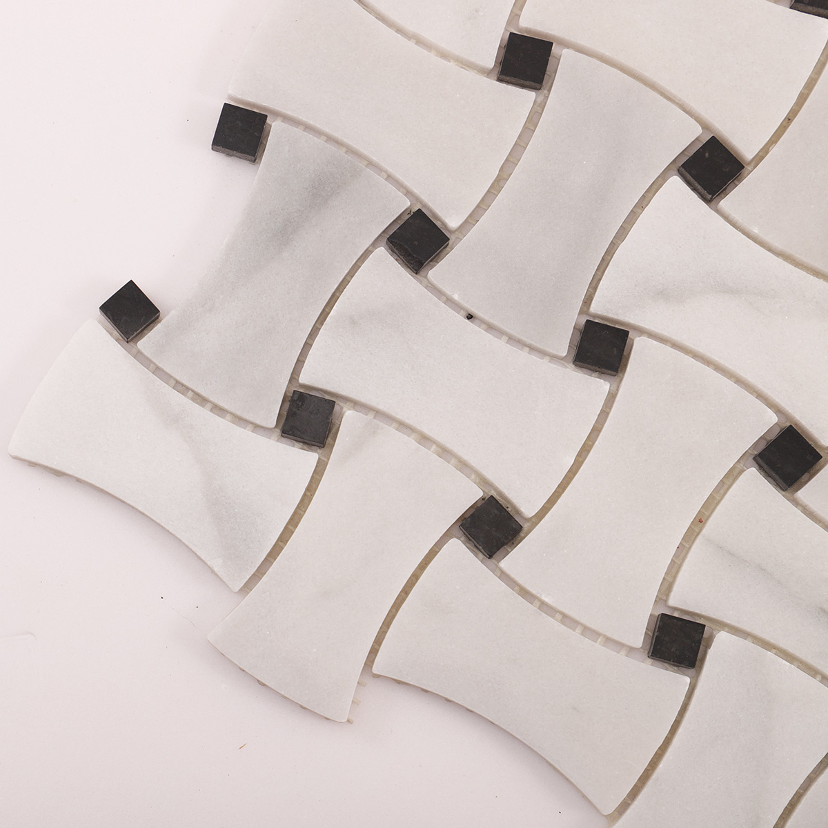 Close-up of Carrara white basketweave marble mosaic tiles with black dots