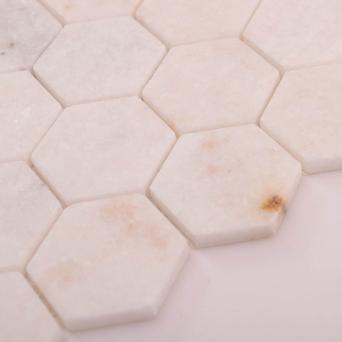 Side close-up view of crystal white hexagon marble mosaic tiles, showing texture and thickness