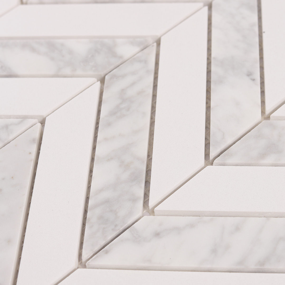Close-up view of Herringbone Carrara White marble mosaic tiles