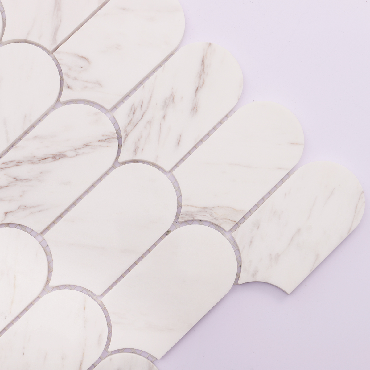 Detailed view of white marble mosaic tile, highlighting soft veins and polished finish