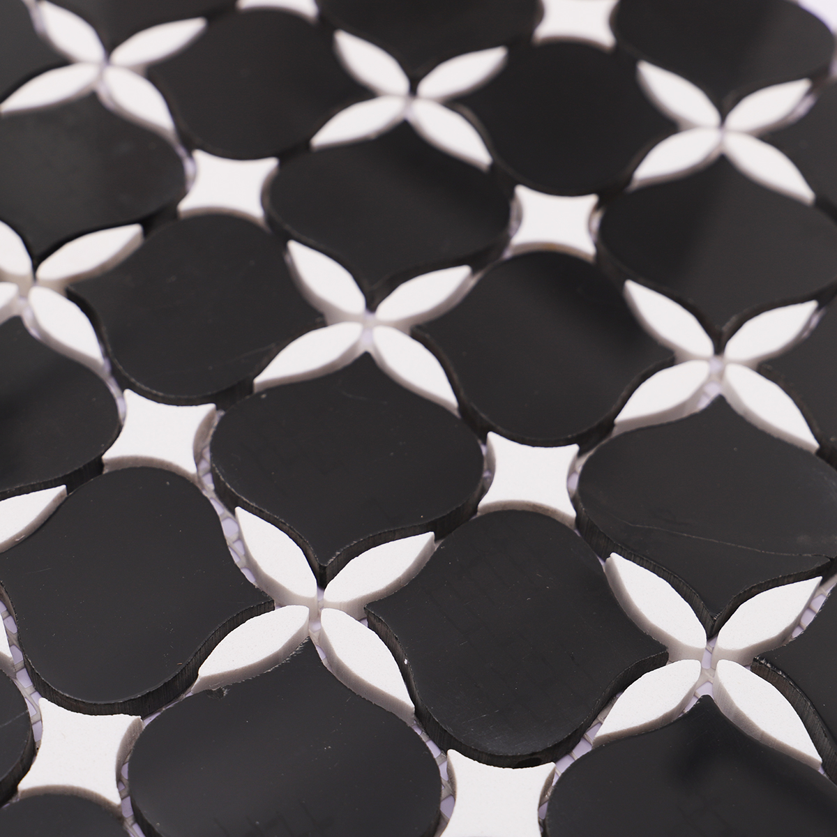 Close-up of black and white stone mosaic tiles, showcasing the intricate floral pattern
