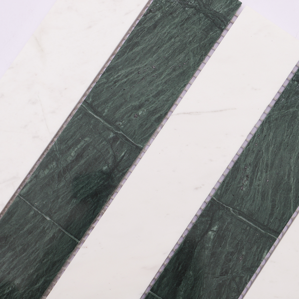 Close-up shot highlighting the surface of green marble and white marble strips