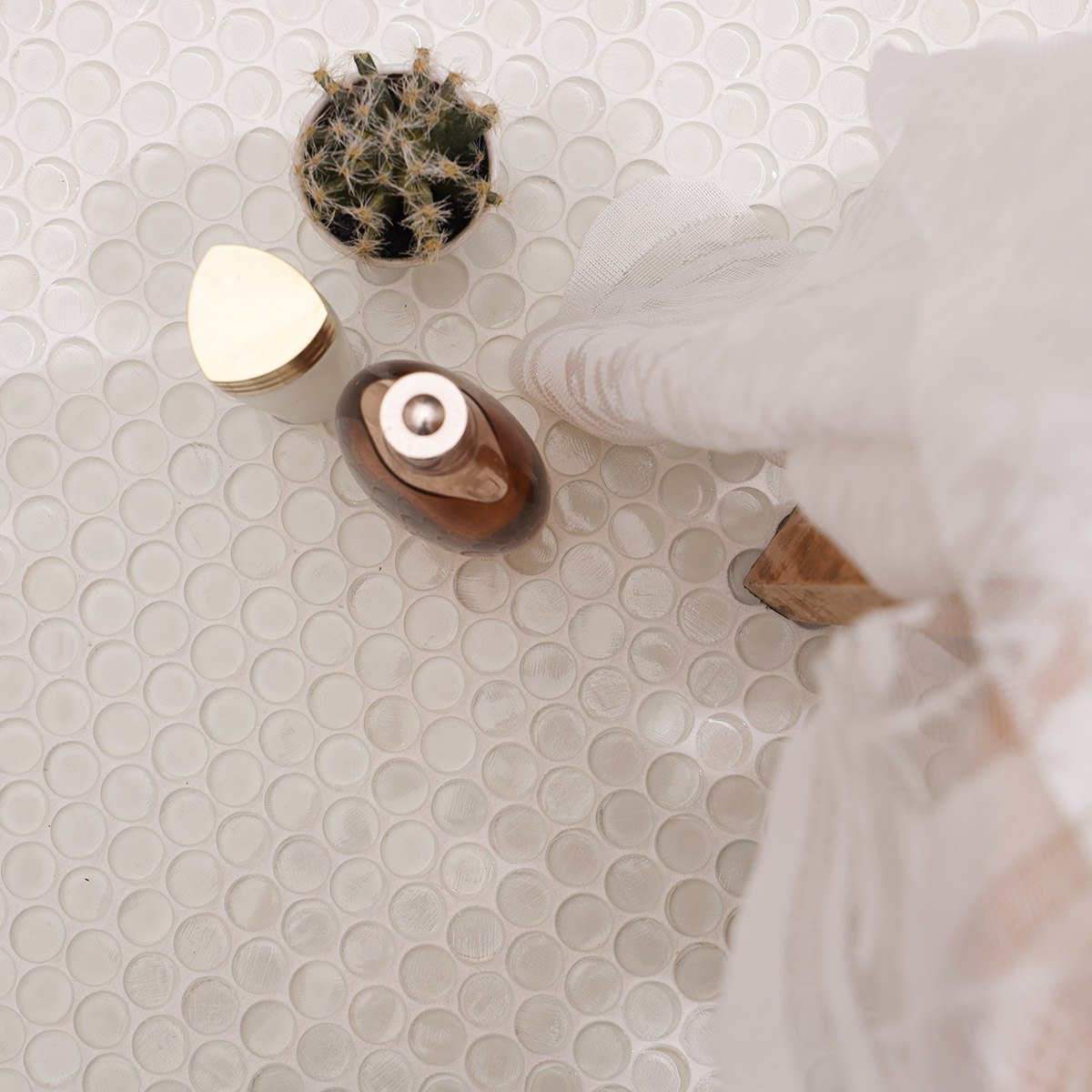 circular mosaic tiles on the floor, with a soft fabric and decorative objects.