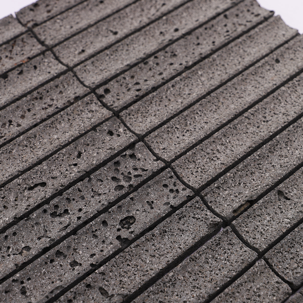 Detailed view showcasing the surface texture of the black lava stone tile