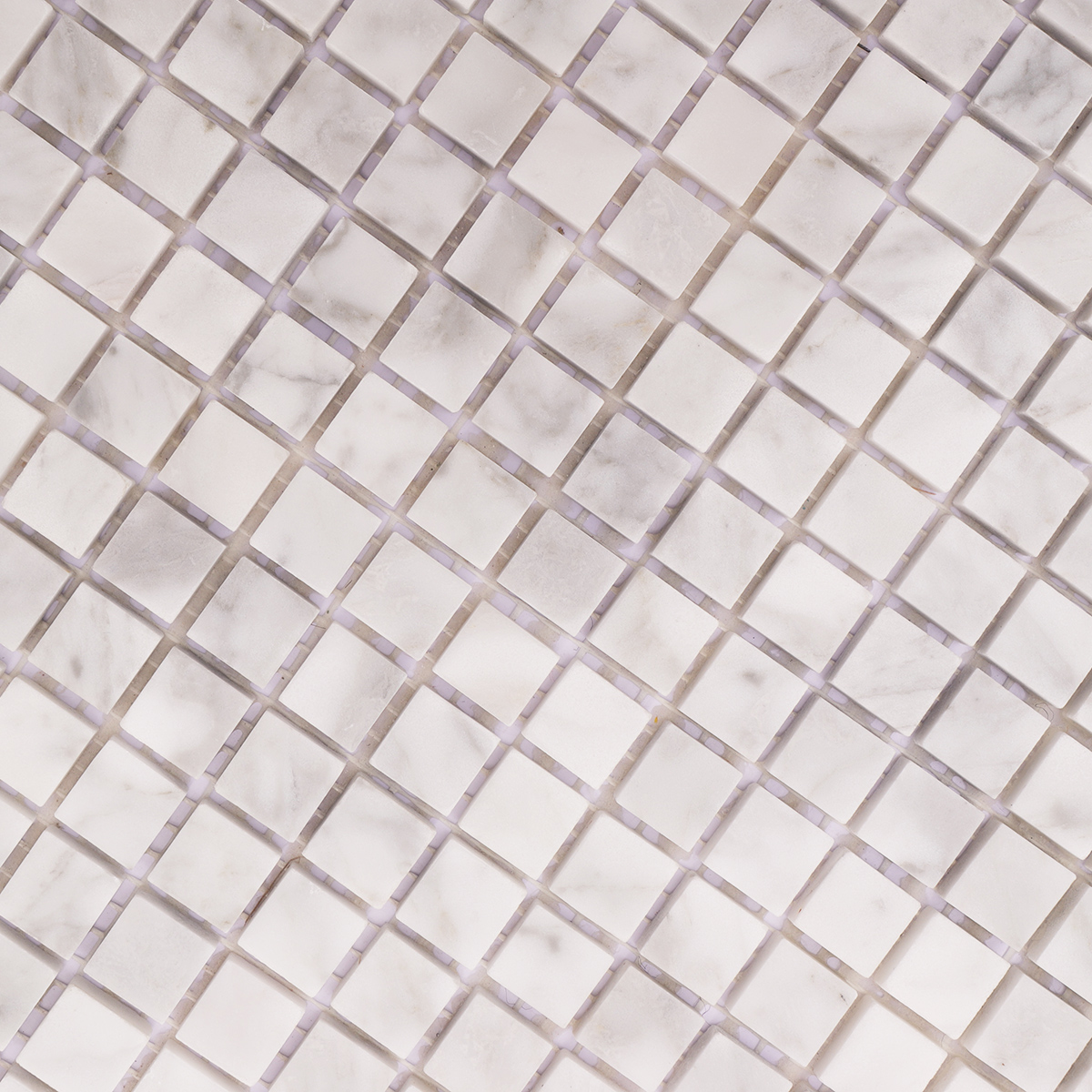 Close-up showing the smooth honed surface of Carrara white marble tiles