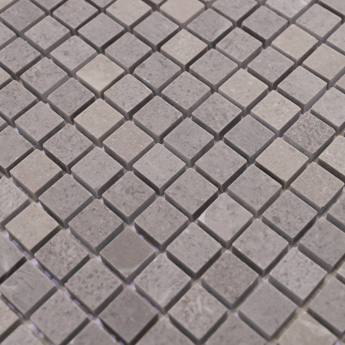 Close-up showing the polished surface of gray marble mosaic tiles.