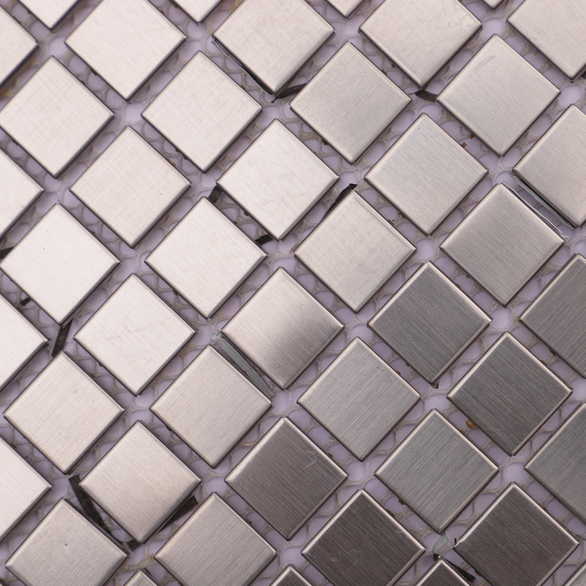 Close-up of the soft brushed texture on stainless steel square tiles.